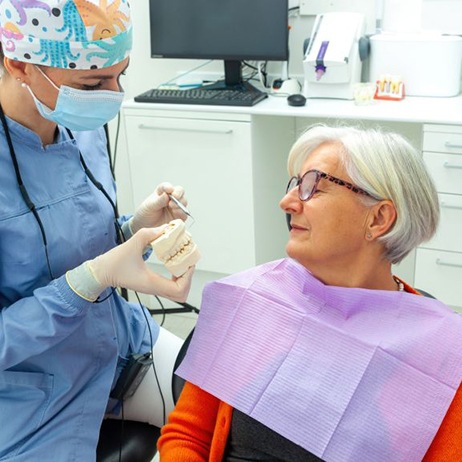 Senior patient talking with dental team member during consultation