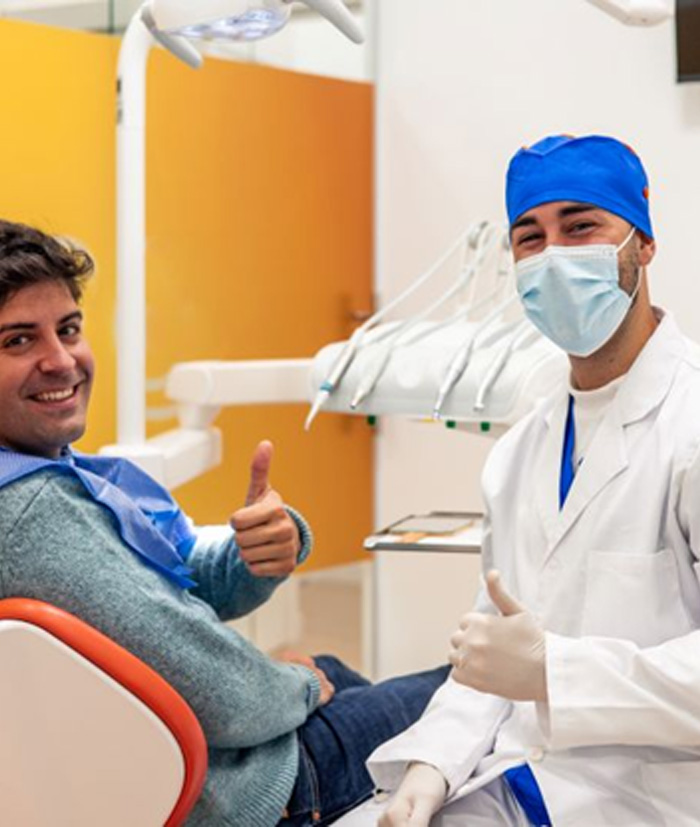 Dentist and dental patient making thumbs-up gesture