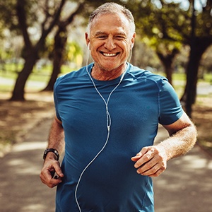 Senior man smiling while jogging outside