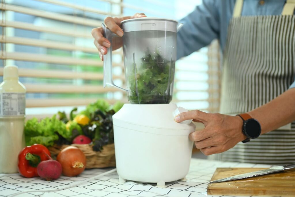 A man making a smoothie in a blender