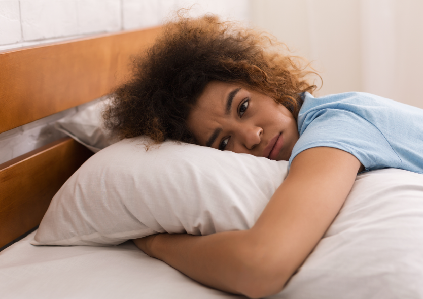 Woman trying to fall asleep, holding pillow