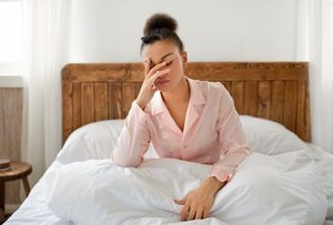Tired woman sitting up in bed